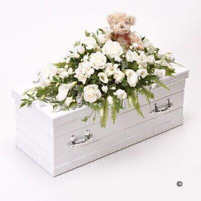 <h2>White Children's Casket Spray with Teddy Bear | Funeral Flowers</h2>
<ul>
<li>Approximate Size 70cm x 30cm</li>
<li>Hand created classic white casket spray in fresh flowers</li>
<li>To give you the best we may occasionally need to make substitutes</li>
<li>Funeral Flowers will be delivered at least 2 hours before the funeral</li>
<li>For delivery area coverage see below</li>
</ul>
<br>
<h2>Liverpool Flower Delivery</h2>
<p>We have a wide selection of casket flowers offered for Liverpool Flower Delivery. Casket flowers can be provided for you in Liverpool, Merseyside and we can organize Funeral flower deliveries for you nationwide. Funeral Flowers can be delivered to the Funeral directors or a house address. They can not be delivered to the crematorium or the church.</p>
<br>
<h2>Flower Delivery Coverage</h2>
<p>Our shop delivers funeral flowers to the following Liverpool postcodes L1 L2 L3 L4 L5 L6 L7 L8 L11 L12 L13 L14 L15 L16 L17 L18 L19 L24 L25 L26 L27 L36 L70 If your order is for an area outside of these we can organise delivery for you through our network of florists. We will ask them to make as close as possible to the image but because of the difference in stock and sundry items it may not be exact.</p>
<br>
<h2>Liverpool Funeral Flowers | Casket Flowers</h2>
<p>This children's casket spray has been loving handcrafted by our expert florists. This graceful casket arrangement includes a soft teddy bear surrounded by a beautiful display of fresh white flowers. Calla Lily, large-headed roses, freesia, lisianthus and September flowers are arranged by hand with seasonal foliages and ivy trails.</p>
<br>
<p>Funeral Casket Flowers the main tribute and are sometimes, depending on the family's wishes, the only flower arrangement. They are usually chosen by the immediate family.</p>
<br>
<p>Casket sprays are placed directly on top of the coffin. The sprays are large diamond shape tributes. The flowers are arranged in floral foam, which means the flowers have a water source meaning they look their very best for the day.</p>
<br>
<p>Containing 3 white roses, 5 white calla lilies, 4 white freesia, 3 white lisianthus, 2 white September flower and seasonal mixed foliage together with a soft teddy bear who sits in the middle of the casket spray.</p>
<br>
<h2>Best Florist in Liverpool</h2>
<p>Trust Award-winning Liverpool Florist, Booker Flowers and Gifts, to deliver funeral flowers fitting for the occasion delivered in Liverpool, Merseyside and beyond. Our funeral flowers are handcrafted by our team of professional fully qualified who not only lovingly hand make our designs but hand-deliver them, ensuring all our customers are delighted with their flowers. Booker Flowers and Gifts your local Liverpool Flower shop.</p>
<br>
<p><em>Janice Crane - 5 Star Review on Google - Funeral Florist Liverpool</em></p>
<br>
<p><em>I recently had to order a floral tribute for my sister in laws funeral and the Booker Flowers team created a beautifully stunning arrangement. Thank you all so much, Janice Crane.</em></p>